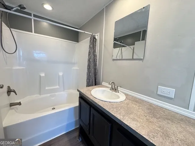 a bathroom with a granite countertop sink mirror and a bathtub