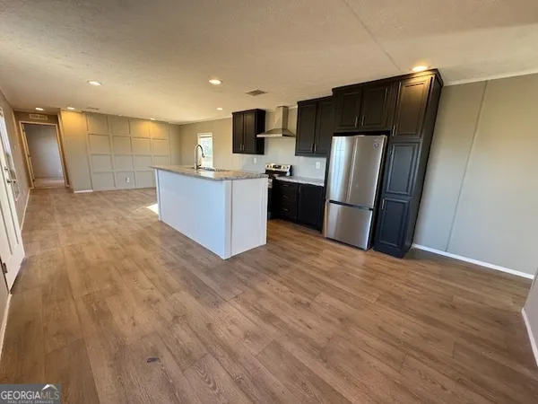 a view of kitchen with refrigerator stove microwave and cabinets