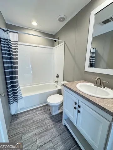 a bathroom with a granite countertop sink toilet a mirror and shower