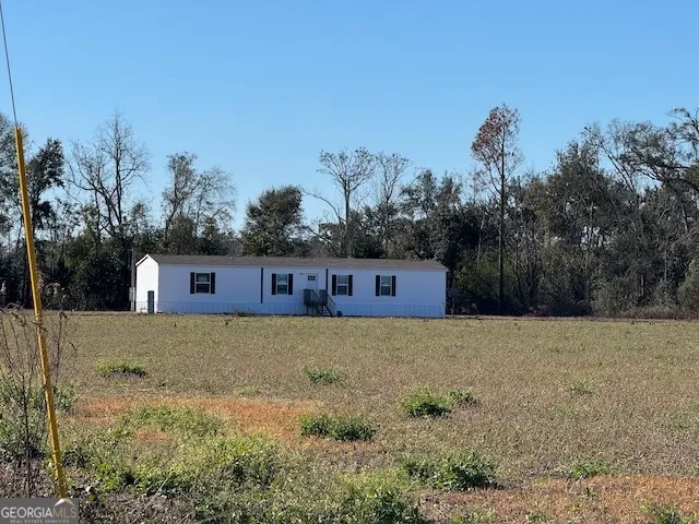 a front view of a house with a yard and trees