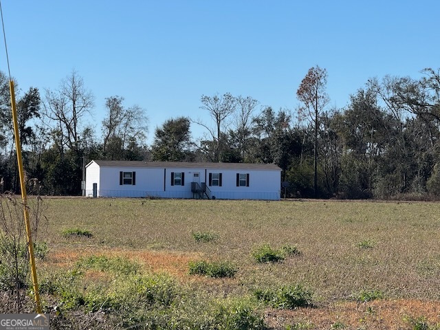 805 Smart Road Alma, GA 31510 - Photo 27 of 41 a front view of a house with a yard and trees