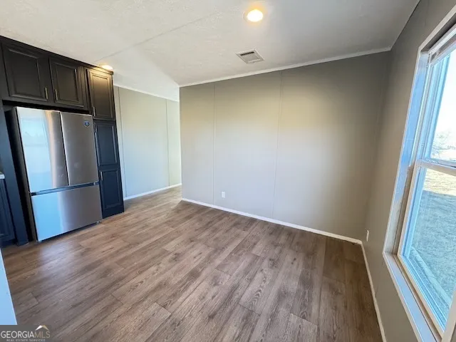 a view of a kitchen with wooden floor and a refrigerator