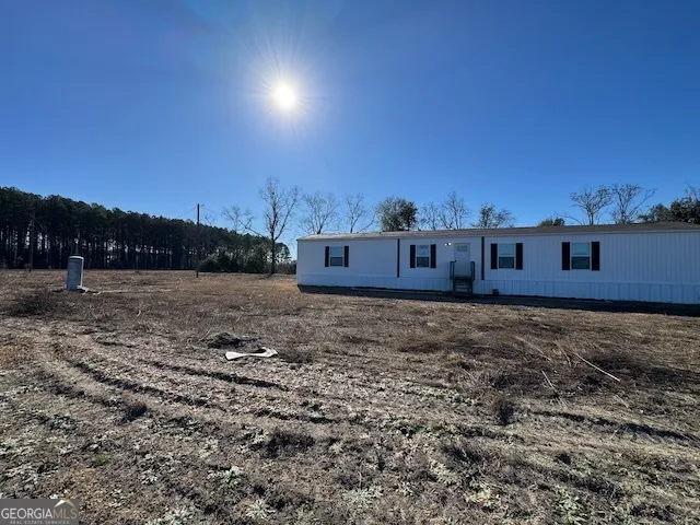 a view of a yard with wooden fence