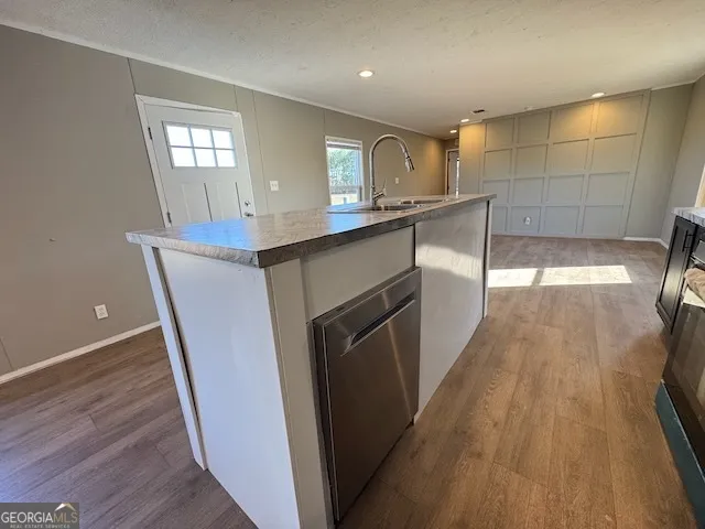 a kitchen with granite countertop a sink a counter space and wooden floor