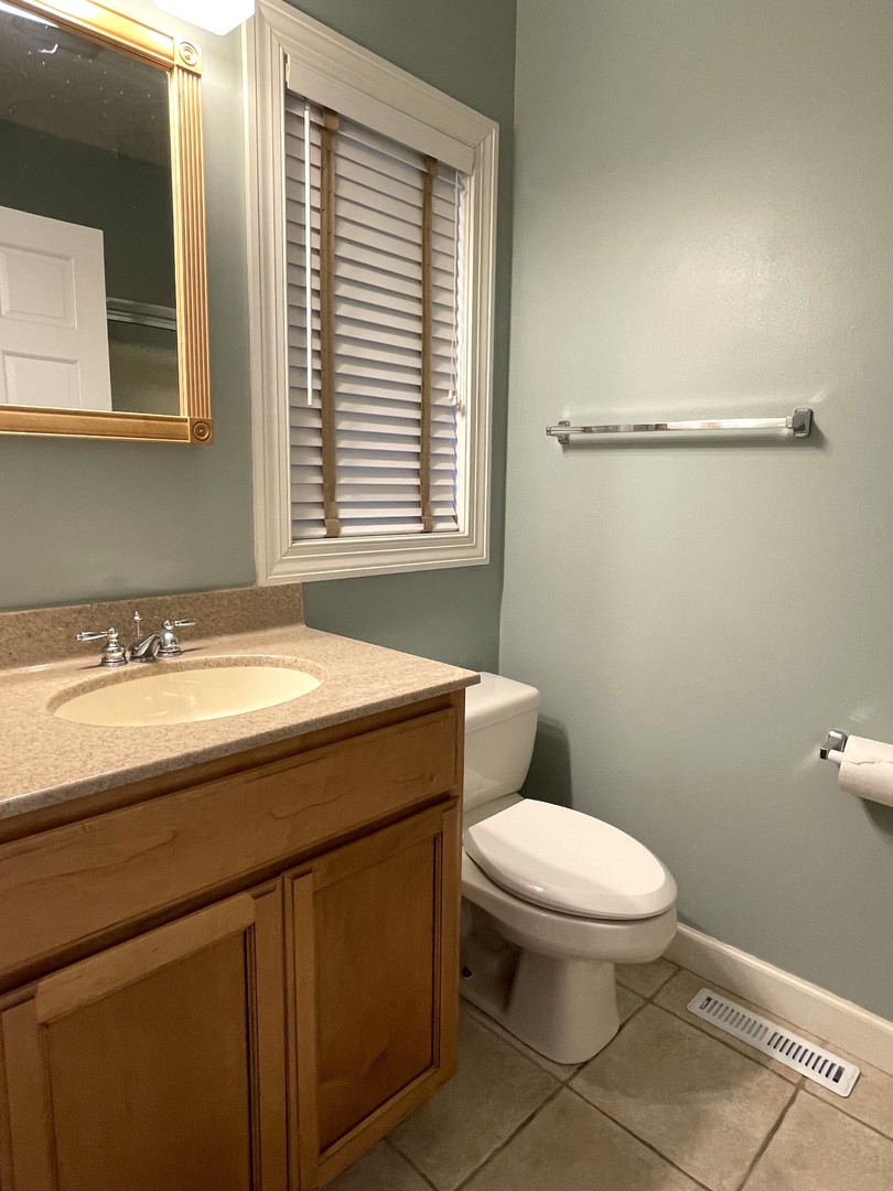 2239 Riverview Road Rock Falls, IL 61071 - Photo 29 of 70 a bathroom with a granite countertop toilet a sink and a window