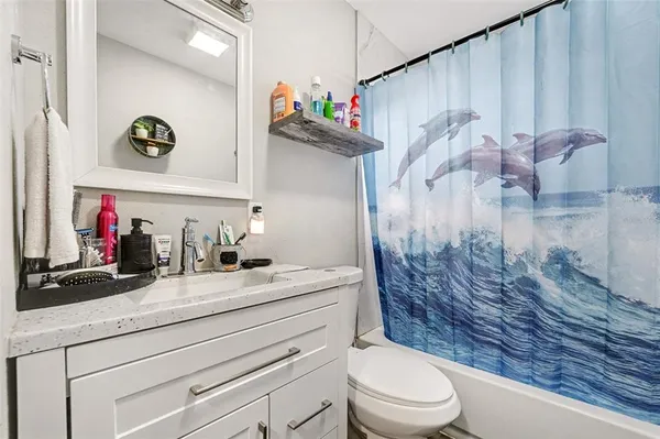 a bathroom with a sink a toilet and shower curtain