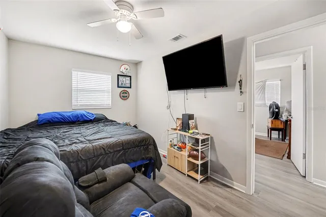 a bedroom with a bed and a flat tv screen on the dresser
