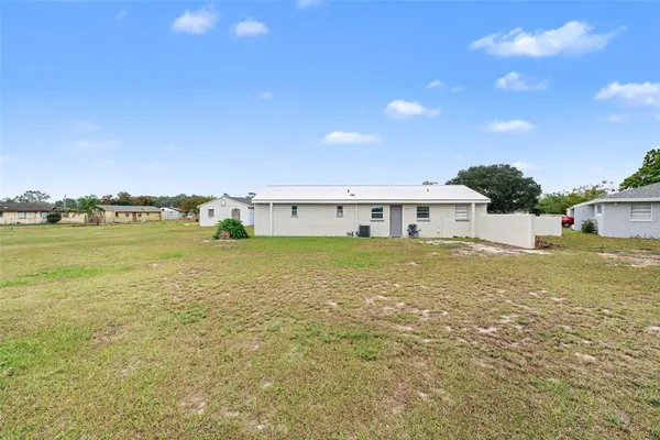 a front view of house with yard and ocean