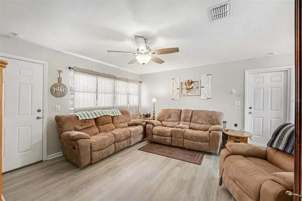 a living room with furniture and a ceiling fan