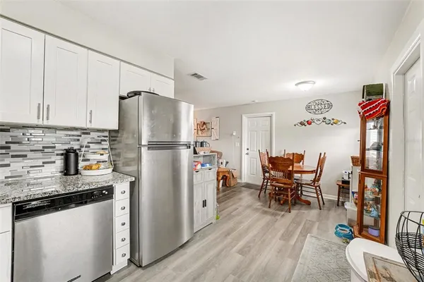 a kitchen with stainless steel appliances granite countertop a refrigerator and a stove top oven