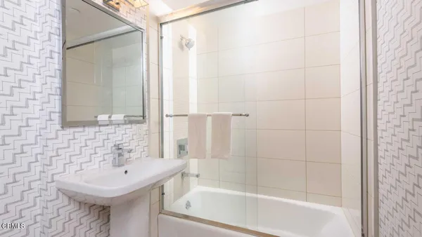 a bathroom with a sink a mirror and a bathtub