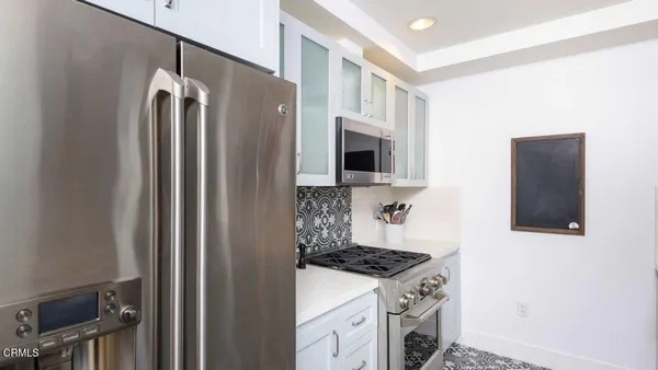 a kitchen with stainless steel appliances granite countertop a refrigerator and a stove top oven