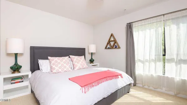 a bedroom with a bed and a large window