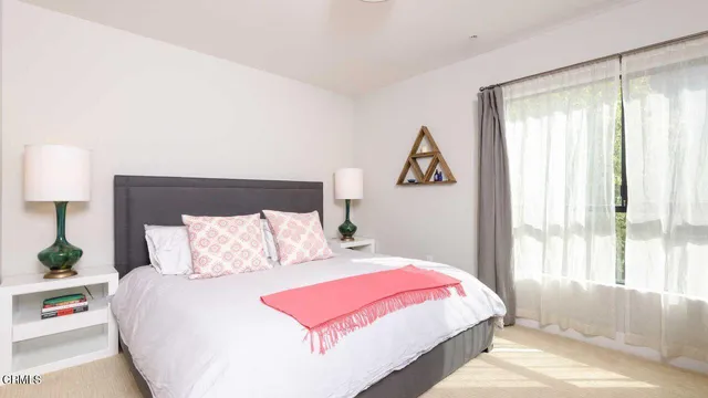 a bedroom with a bed and a large window