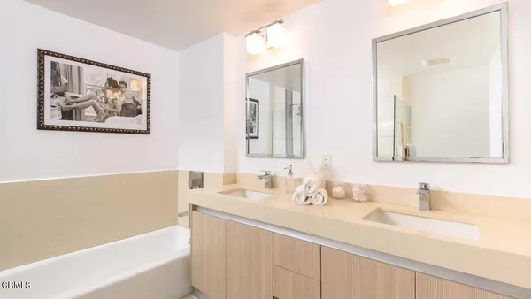 a bathroom with a tub a sink and mirror