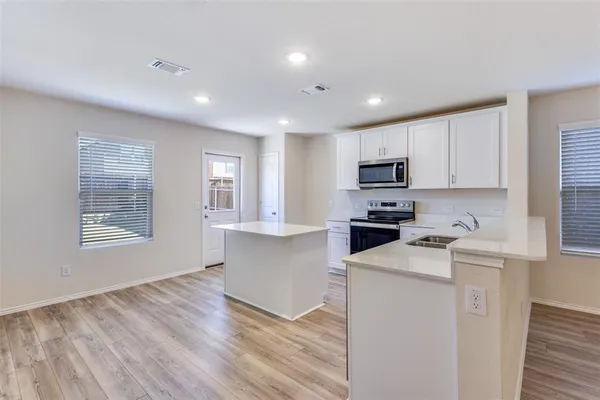 a kitchen with granite countertop white cabinets and white appliances