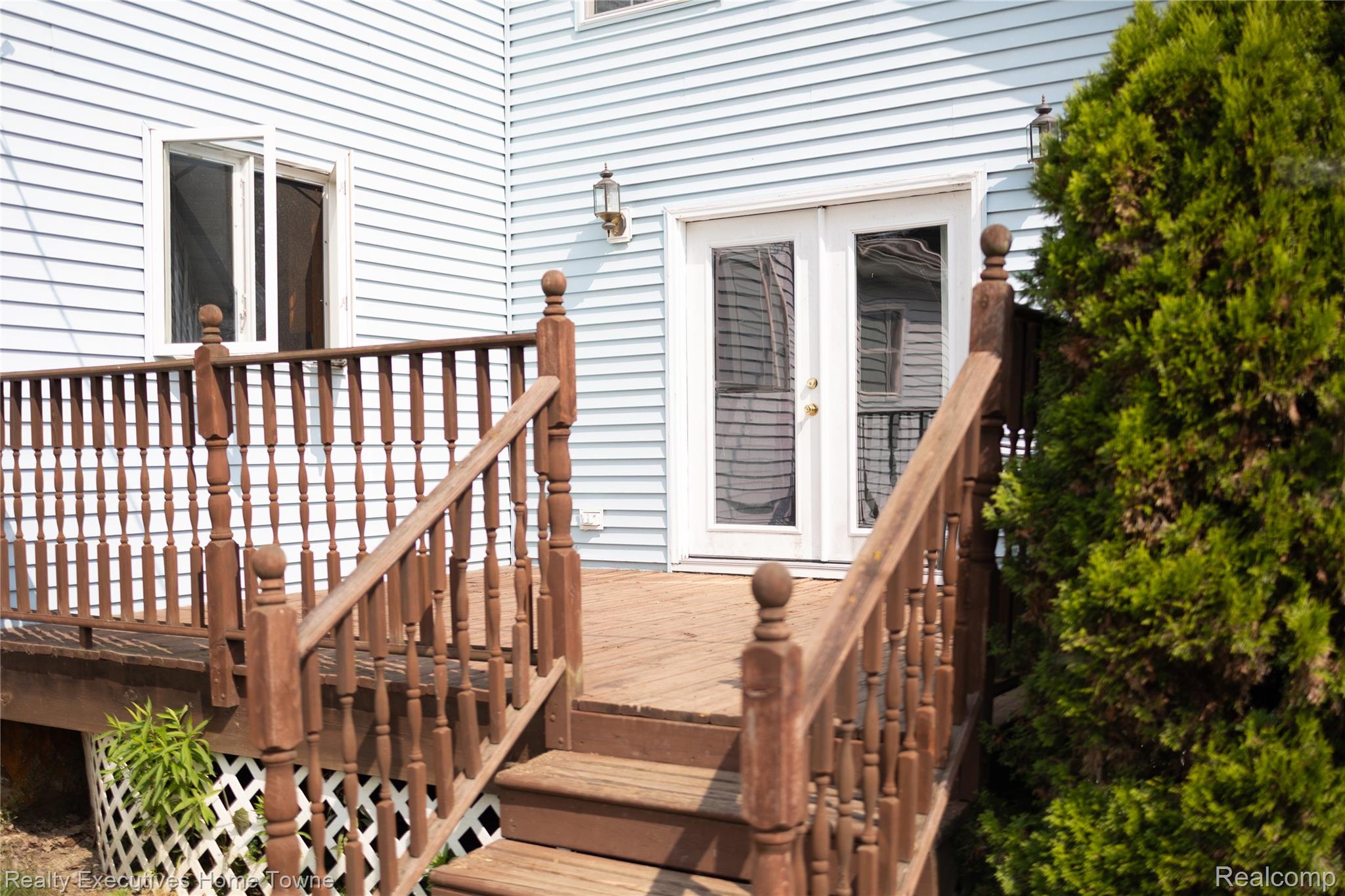 2715 Cash Road Applegate, MI 48401 - Photo 11 of 59 Exterior deck with wooden railings and balusters, featuring light blue vinyl siding