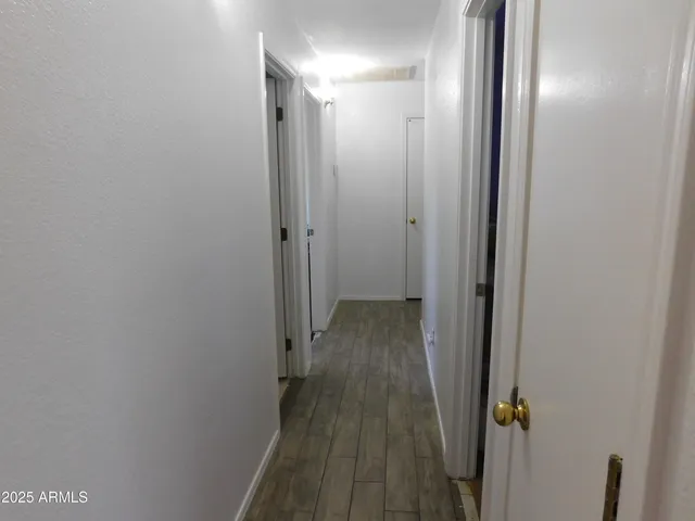 a bedroom with a bed window and wooden floor