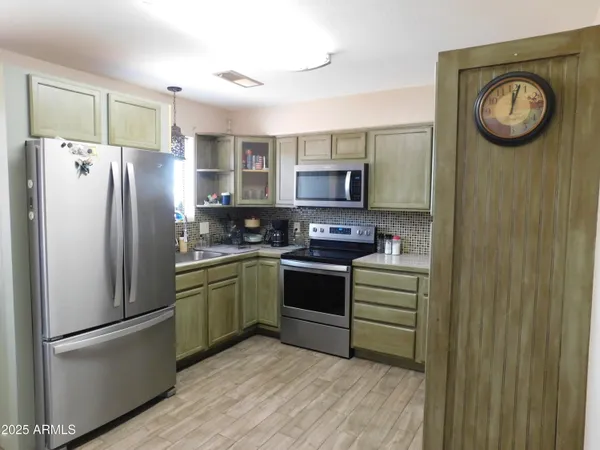 a kitchen with stainless steel appliances granite countertop a refrigerator a stove and a wooden floors