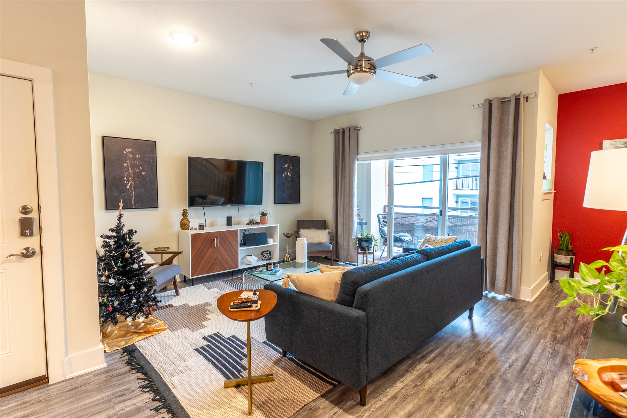 2827 Manor Road, Unit 2202 Austin, TX 78722 - Photo 9 of 20 A well-lit living area features wood flooring and direct access to an outdoor patio through sliding glass doors.