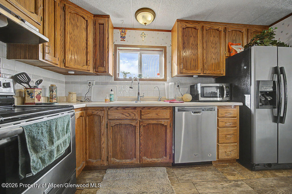 723 Barbara Drive Craig, CO 81625 - Photo 30 of 48 a kitchen with stainless steel appliances granite countertop a sink stove and refrigerator