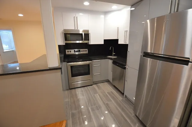 a kitchen with stainless steel appliances a refrigerator sink and microwave