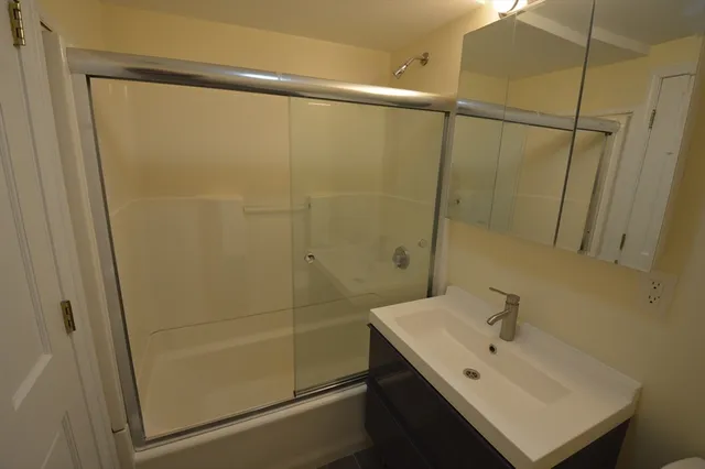 a bathroom with a sink a toilet and shower
