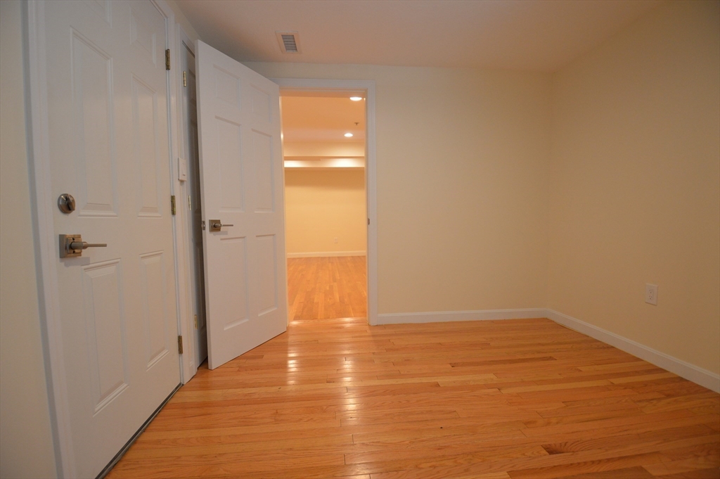 1801 Beacon Street, Unit 2 Brookline, MA 02445 - Photo 9 of 14 a view of an empty room with wooden floor and a shower