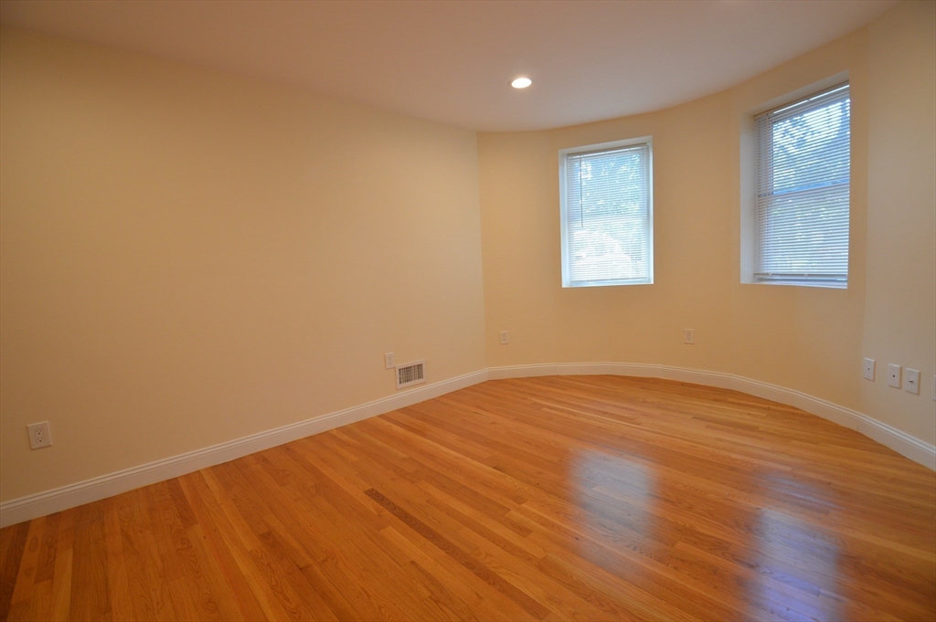 1801 Beacon Street, Unit 2 Brookline, MA 02445 - Photo 10 of 14 a view of an empty room with wooden floor and a window