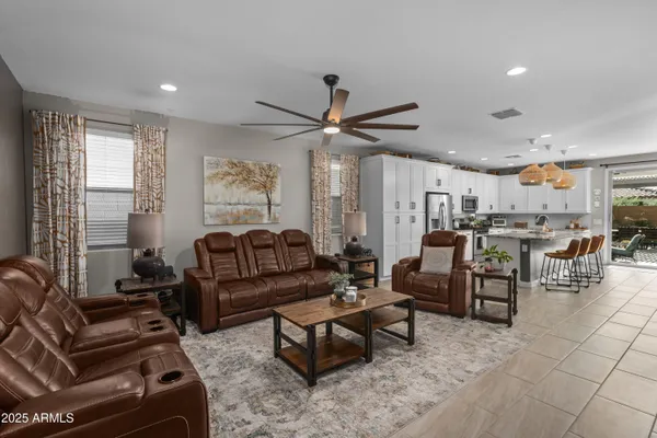 a kitchen with granite countertop a stove a sink dishwasher a dining table and chairs with wooden floor