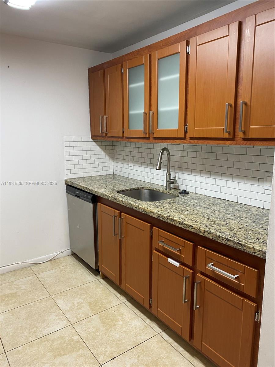 301 Southwest 135th Avenue, Unit 209C Pembroke Pines, FL 33027 - Photo 3 of 14 a kitchen with granite countertop a sink and a wooden cabinets