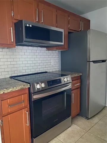 a kitchen with granite countertop cabinets and steel stainless steel appliances