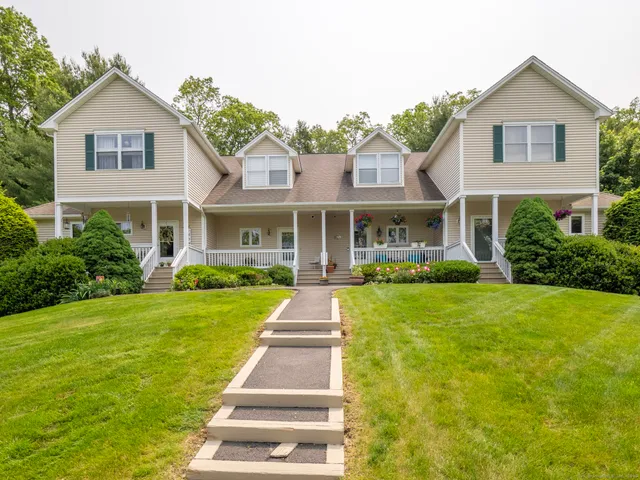 a front view of a house with yard and green space
