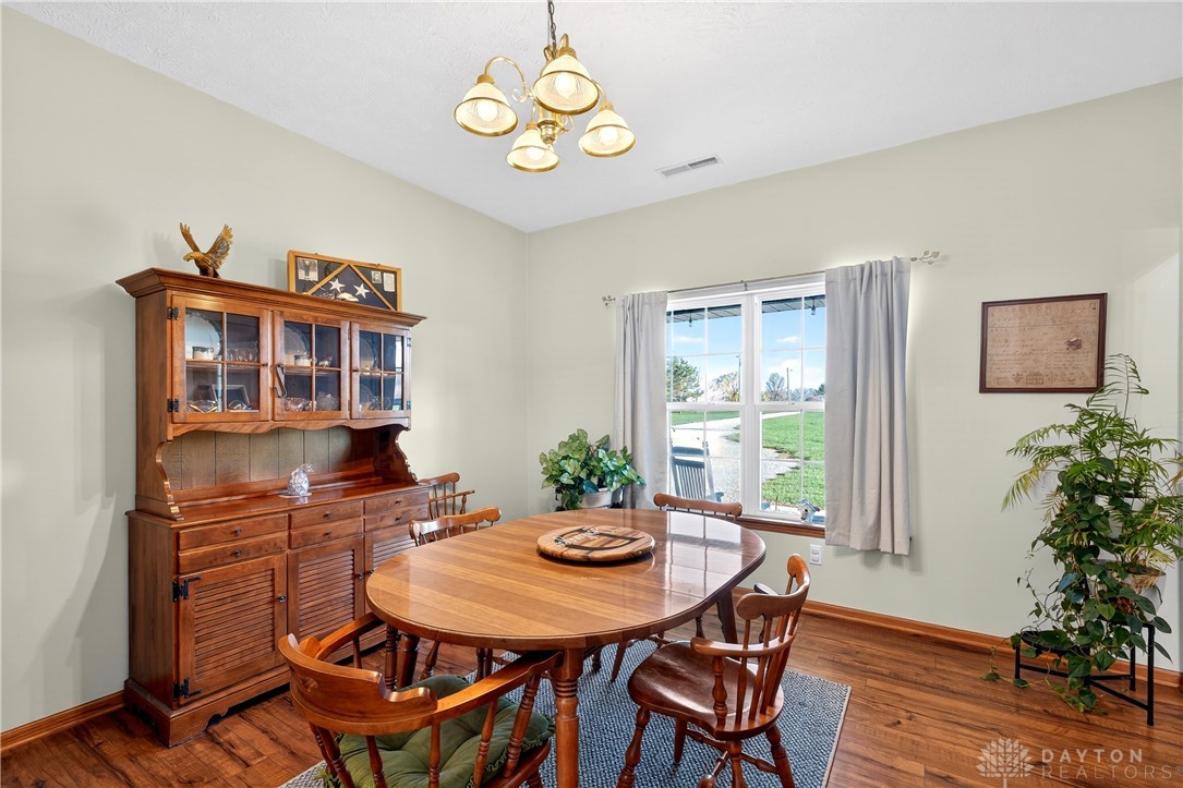 6560 Snyder Road Fletcher, OH 45326 - Photo 11 of 71 This dining room boasts rich hardwood flooring and a charming chandelier, perfect for intimate gatherings.