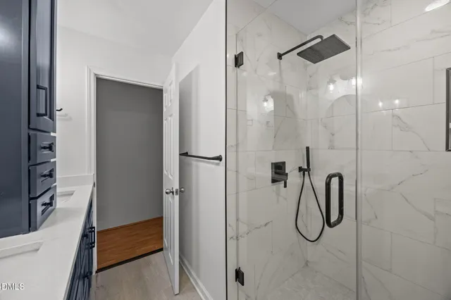 a bathroom with a shower and a glass door
