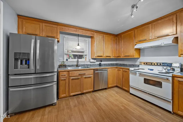 a kitchen with stainless steel appliances a stove a sink and a refrigerator