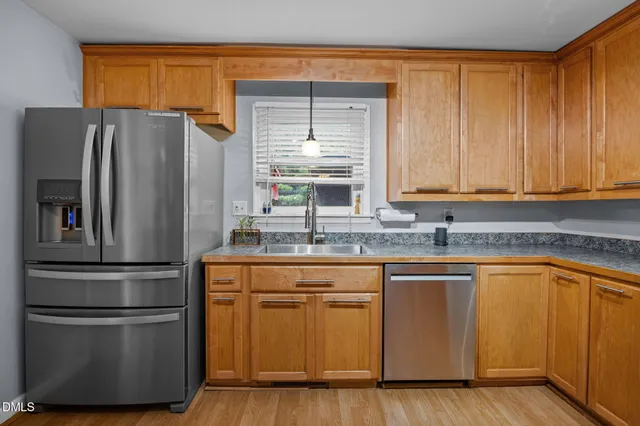 a kitchen with stainless steel appliances granite countertop a refrigerator a sink and a stove