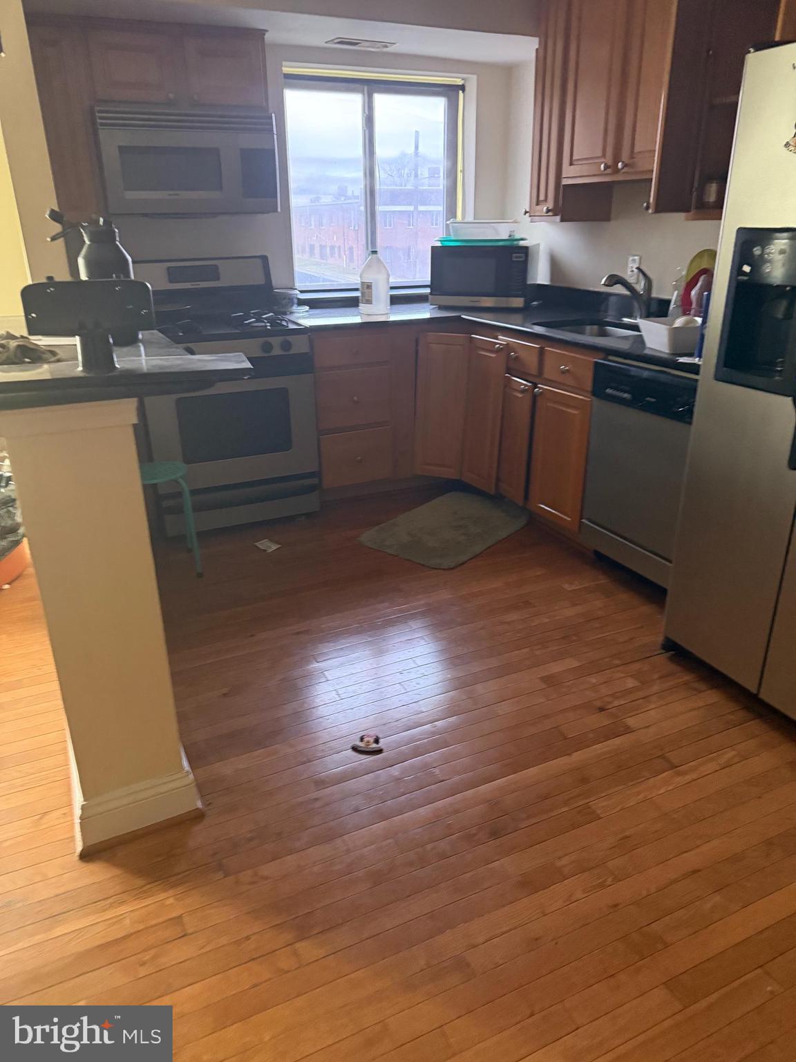 2215 Hunter Place Southeast, Unit 303 Washington, DC 20020 - Photo 2 of 4 a kitchen with stainless steel appliances granite countertop a stove a sink and a microwave