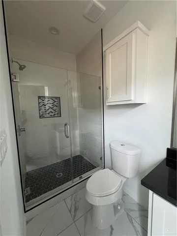 a bathroom with a toilet and a shower