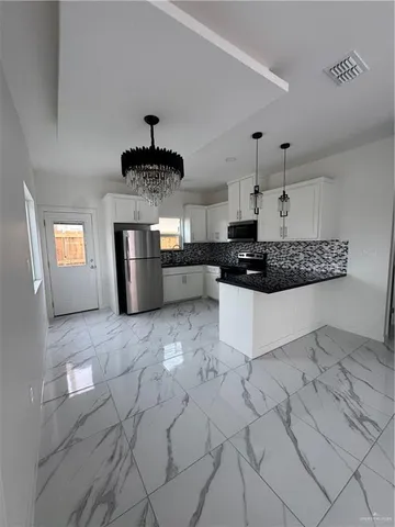 a kitchen with stainless steel appliances granite countertop a stove a sink and a refrigerator