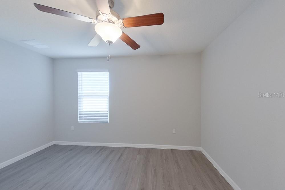 4397 Southwest 85th Lane Ocala, FL 34476 - Photo 6 of 23 an empty room with wooden floor chandelier fan and windows