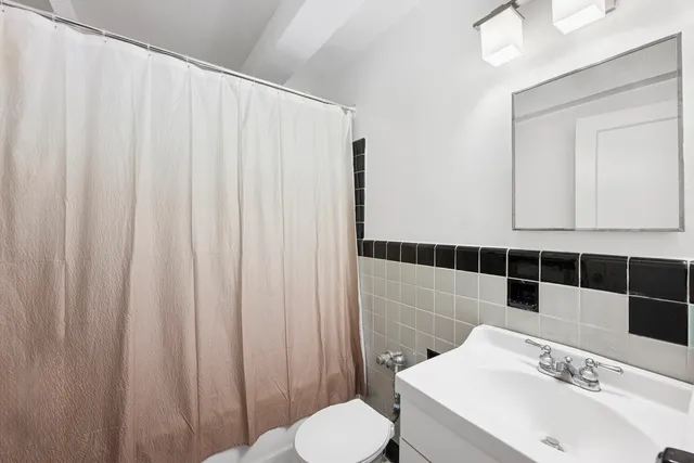 a bathroom with a sink a toilet and shower curtain