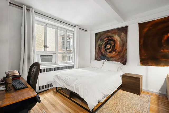 a bedroom with a bed and a flat tv screen on dresser