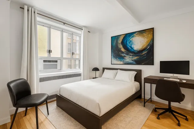 a bedroom with a bed a couch and a window