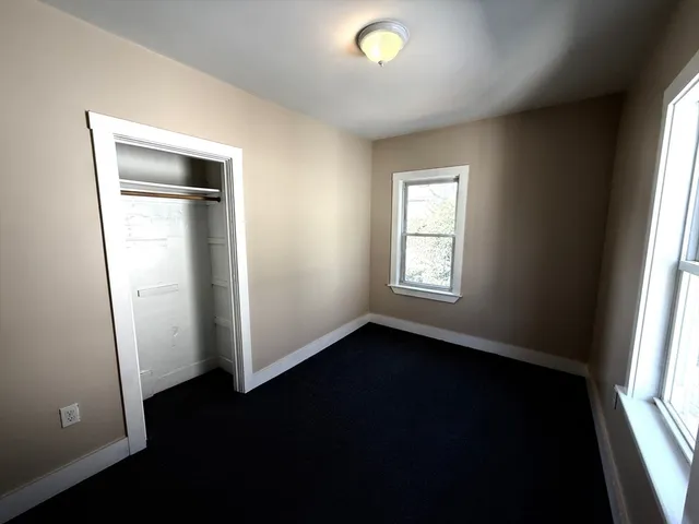 an empty room with closet and windows