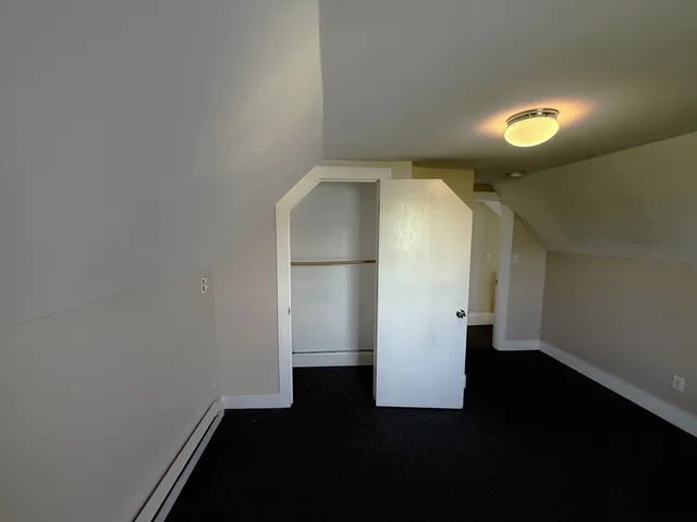 an empty room with wooden floor and a window