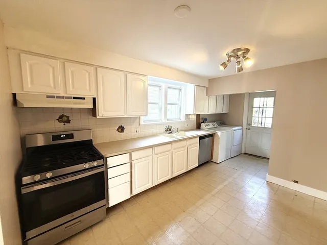 a kitchen with granite countertop white cabinets and white appliances