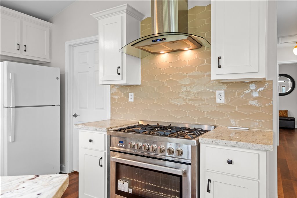 608 Whistleville Road Flatonia, TX 78941 - Photo 5 of 26 If you love to cook, you are going to appreciate this stove setup. It's a high-end, professional-grade stainless steel gas range, complete with a gorgeous curved glass vent hood. The neutral hexagon tile backsplash ties everything together beautifully.