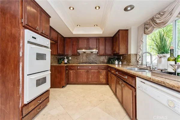 a kitchen with granite countertop a stove top oven sink and cabinets