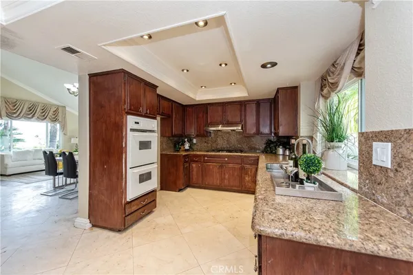 a kitchen with stainless steel appliances granite countertop a stove refrigerator and sink